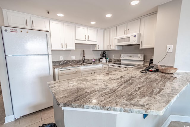 kitchen featuring sink, white cabinetry, light tile patterned floors, kitchen peninsula, and white appliances