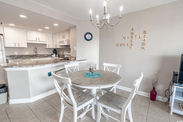 tiled dining space with sink and a notable chandelier