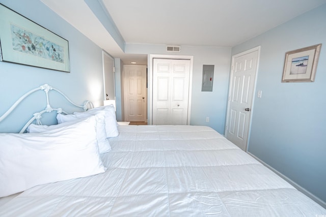 bedroom featuring electric panel and a closet