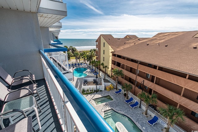 balcony featuring a water view and a community hot tub