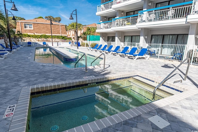 view of pool featuring a community hot tub and a patio