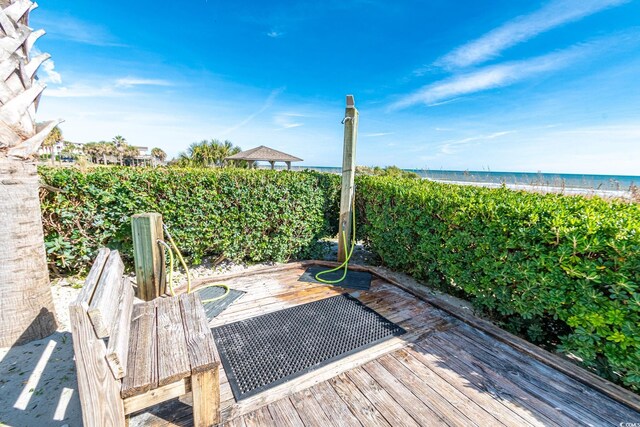 deck featuring a view of the beach and a water view