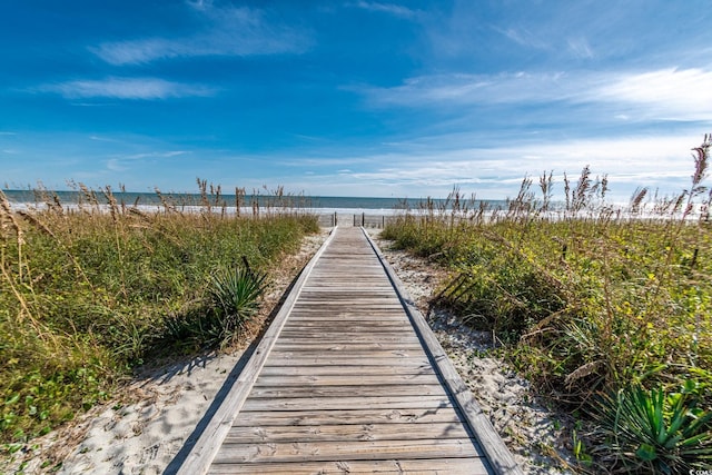 surrounding community with a water view and a view of the beach