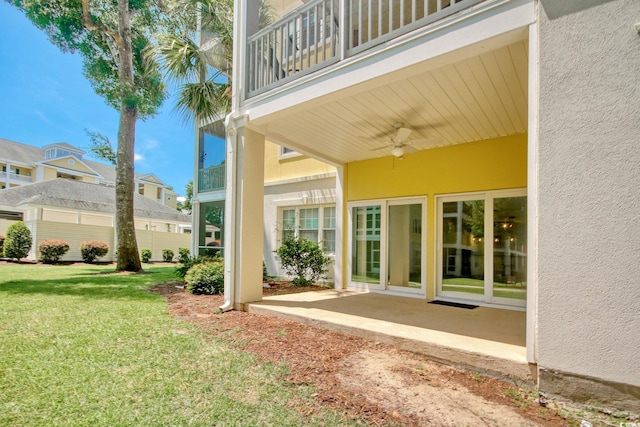 view of yard featuring a patio, a balcony, and ceiling fan