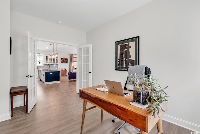 office with wood-type flooring and french doors