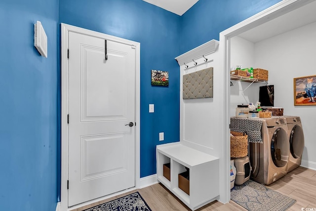 mudroom with washing machine and clothes dryer and light hardwood / wood-style floors