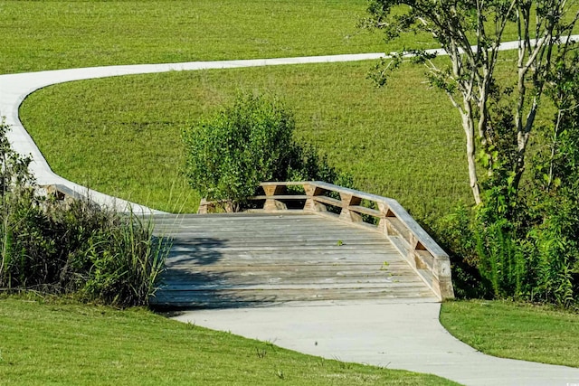 surrounding community featuring a wooden deck and a lawn