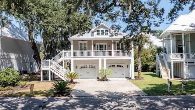 coastal inspired home with covered porch, driveway, stairway, and a front lawn