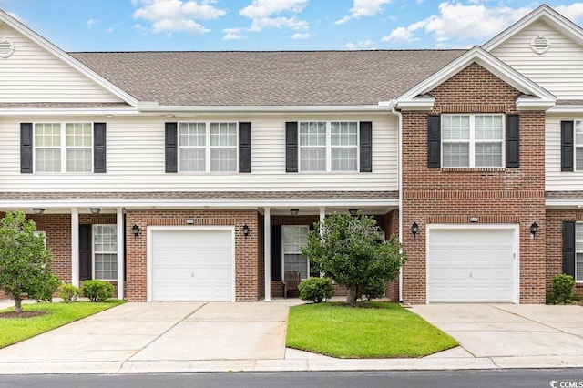 multi unit property featuring a garage, driveway, brick siding, and a shingled roof