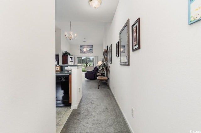 hallway with an inviting chandelier and light carpet