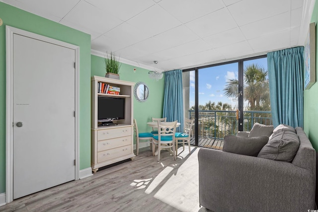 living area featuring floor to ceiling windows, baseboards, and wood finished floors