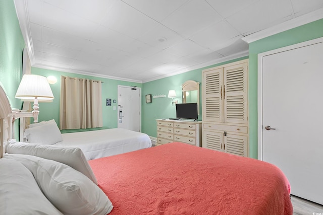 bedroom featuring wood finished floors and crown molding