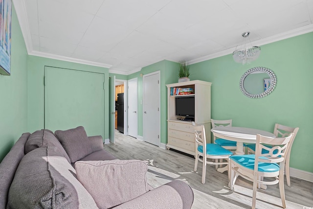 living area with baseboards, wood finished floors, and crown molding