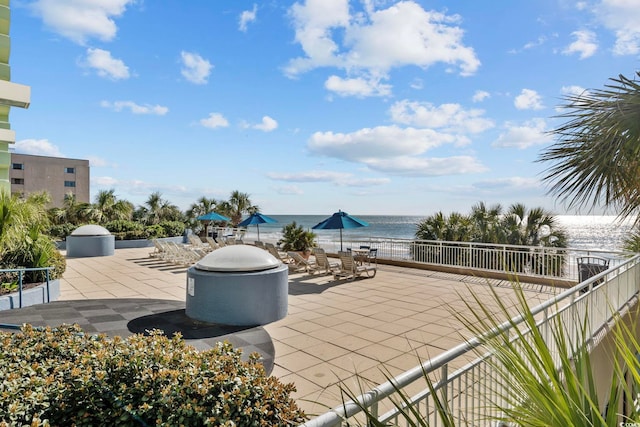 view of patio featuring a water view and fence