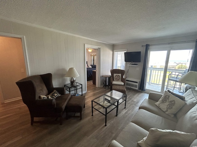 living room featuring hardwood / wood-style flooring, crown molding, and a textured ceiling