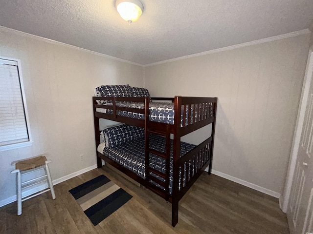 bedroom with ornamental molding, dark hardwood / wood-style floors, and a textured ceiling