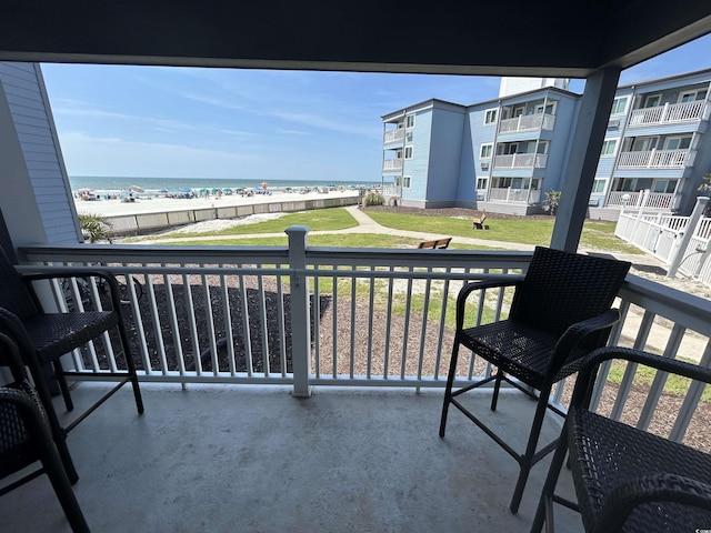 balcony with a water view and a beach view