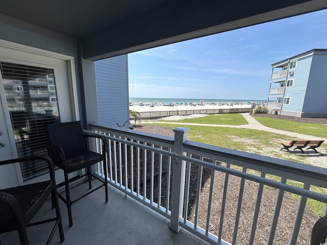 balcony featuring a water view and a view of the beach