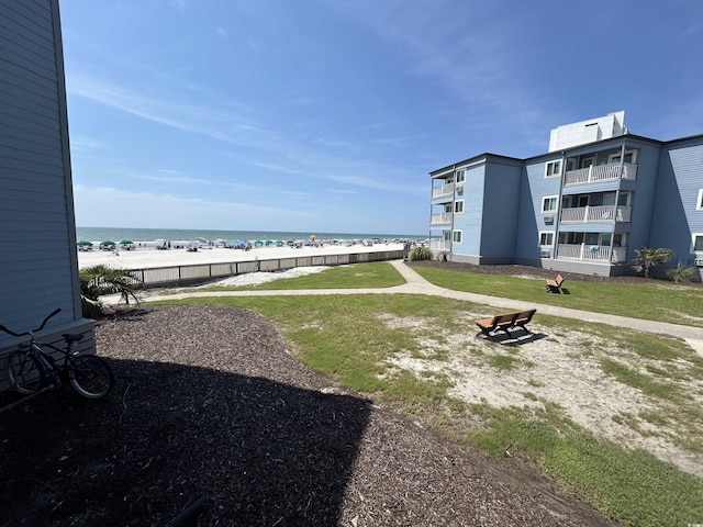 view of property's community with a water view and a view of the beach