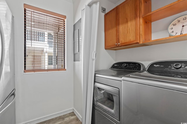 laundry area featuring cabinets, washer and dryer, and dark hardwood / wood-style flooring