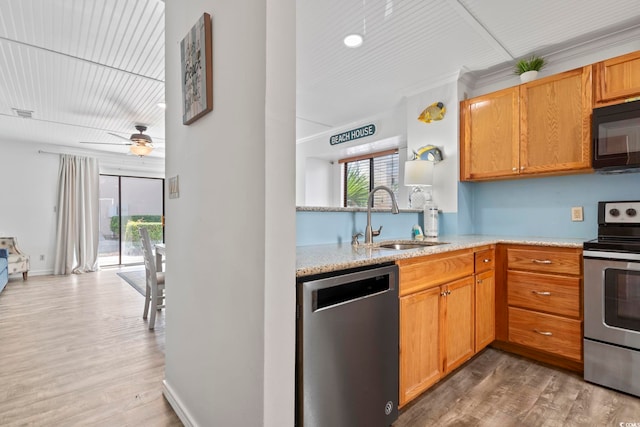 kitchen with stainless steel appliances, a healthy amount of sunlight, wood-type flooring, and sink