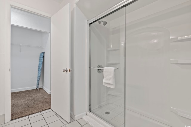 bathroom with tile patterned floors and a shower with door