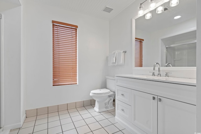 bathroom featuring tile patterned flooring, vanity, a shower with door, and toilet