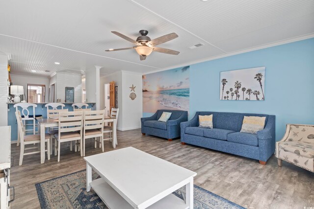 living room with crown molding, ceiling fan, and wood-type flooring