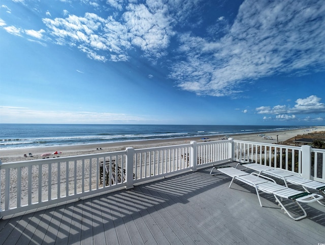 wooden terrace featuring a view of the beach and a water view