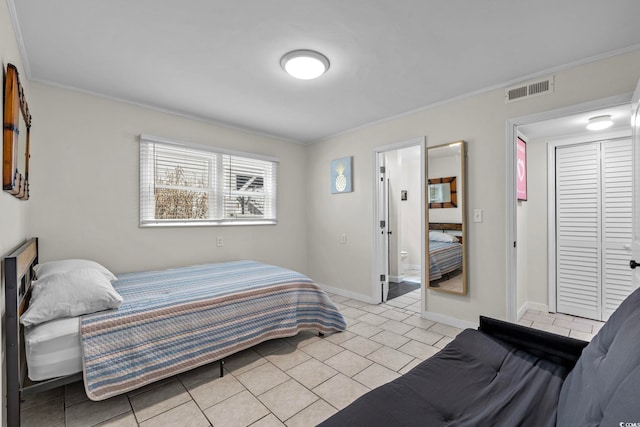 bedroom with a closet, connected bathroom, and ornamental molding