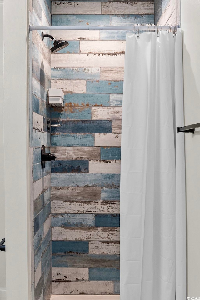 bathroom featuring a shower with curtain and wood walls