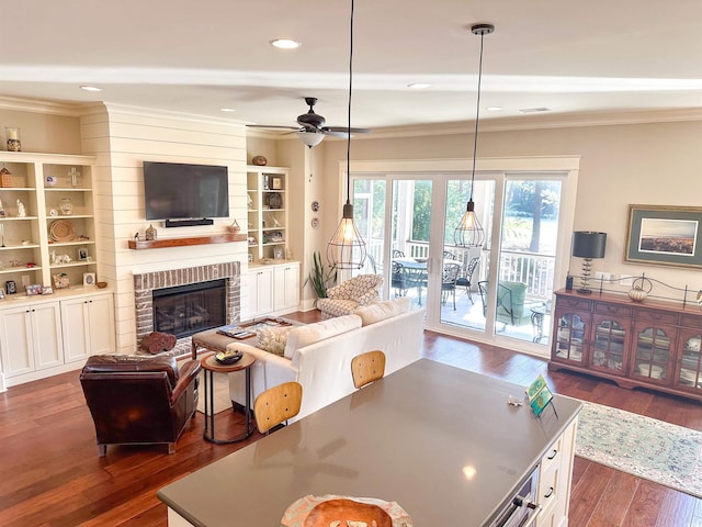 living room featuring ornamental molding, a fireplace, dark hardwood / wood-style floors, and ceiling fan