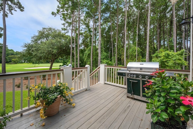 wooden terrace with a lawn and a grill