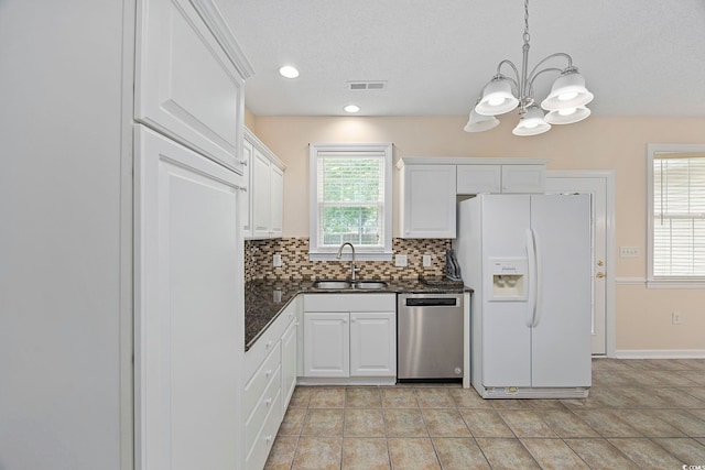 kitchen featuring decorative light fixtures, tasteful backsplash, stainless steel dishwasher, sink, and white fridge with ice dispenser