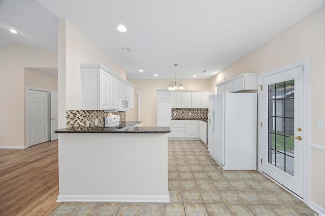 kitchen featuring vaulted ceiling, white appliances, hanging light fixtures, kitchen peninsula, and decorative backsplash