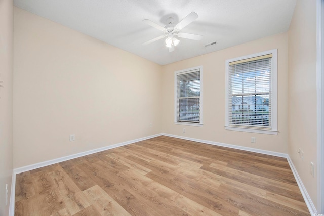 empty room with light hardwood / wood-style flooring and ceiling fan