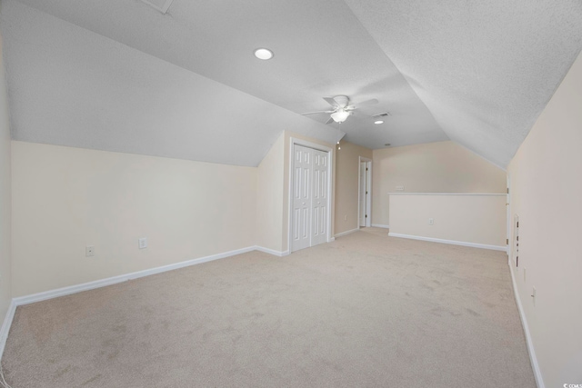 bonus room featuring a textured ceiling, ceiling fan, light carpet, and vaulted ceiling