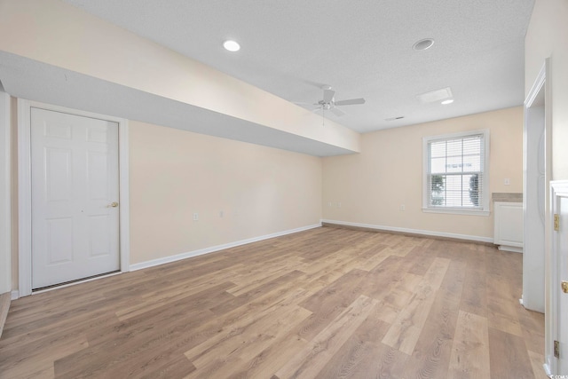 interior space with a textured ceiling, ceiling fan, and light hardwood / wood-style floors