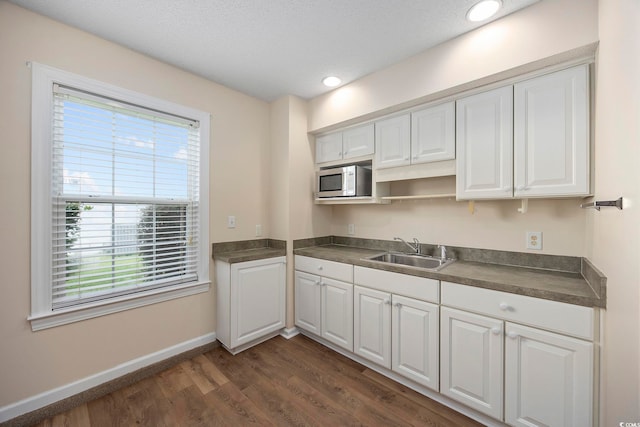 kitchen featuring a textured ceiling, white cabinetry, sink, and dark hardwood / wood-style floors