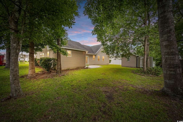 yard at dusk featuring an outbuilding