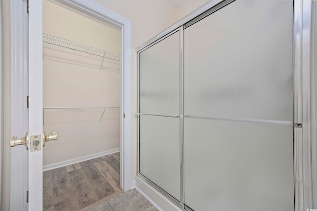 bathroom featuring hardwood / wood-style flooring and a shower with shower door