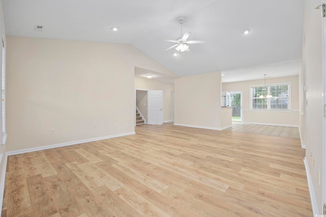 unfurnished living room with ceiling fan with notable chandelier, lofted ceiling, and light hardwood / wood-style floors