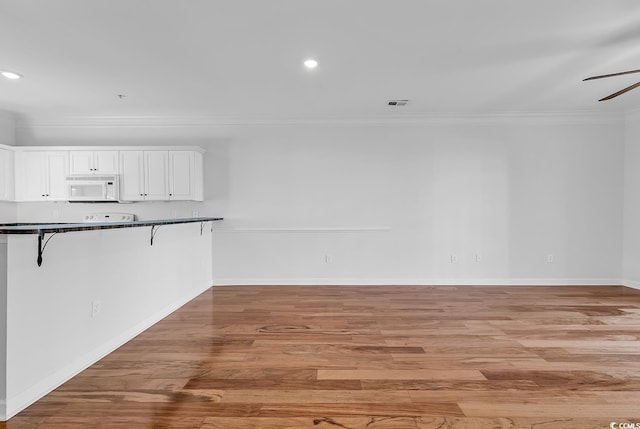 interior space with ornamental molding, light wood-type flooring, and ceiling fan