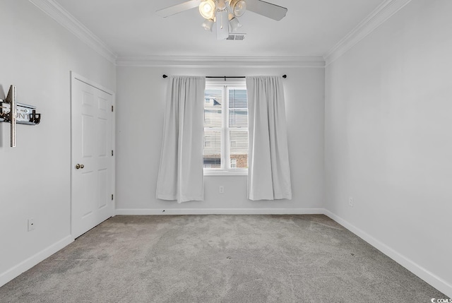 spare room with ceiling fan, light colored carpet, and crown molding