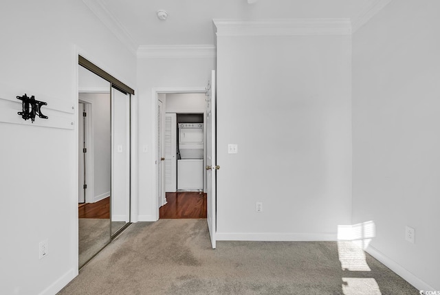 unfurnished bedroom with carpet floors, ornamental molding, and a closet