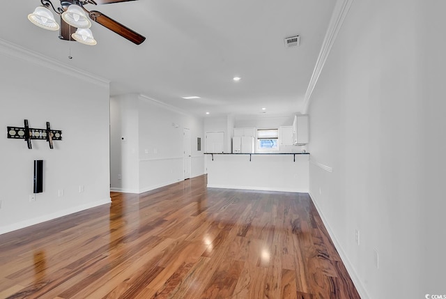 unfurnished living room with ceiling fan, ornamental molding, and wood-type flooring