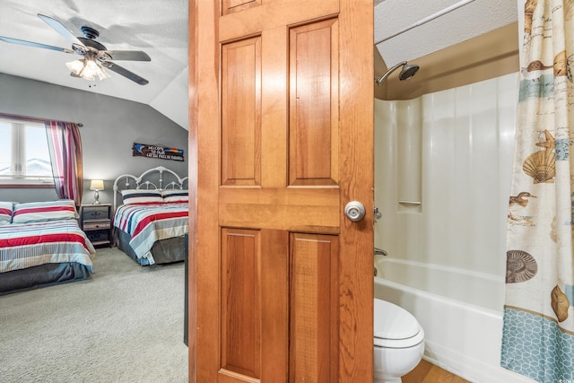 bathroom with a textured ceiling, vaulted ceiling, ceiling fan, shower / bathtub combination with curtain, and toilet