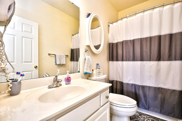 bathroom with curtained shower, vanity, and toilet