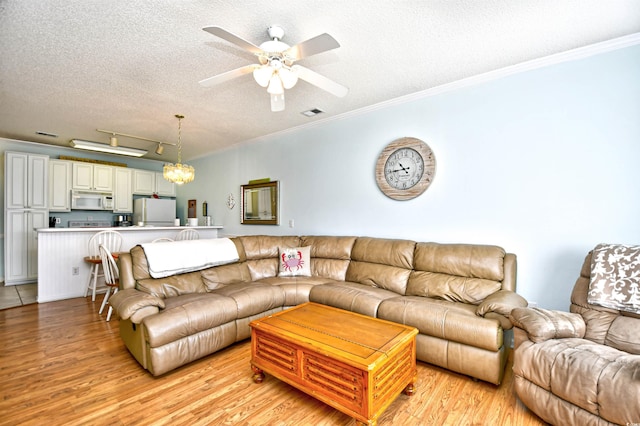 living room with a textured ceiling, ceiling fan with notable chandelier, crown molding, and light hardwood / wood-style flooring