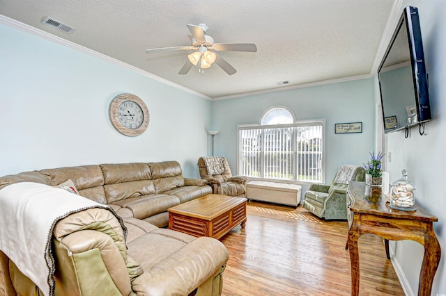 living room featuring light hardwood / wood-style flooring, ceiling fan, and crown molding